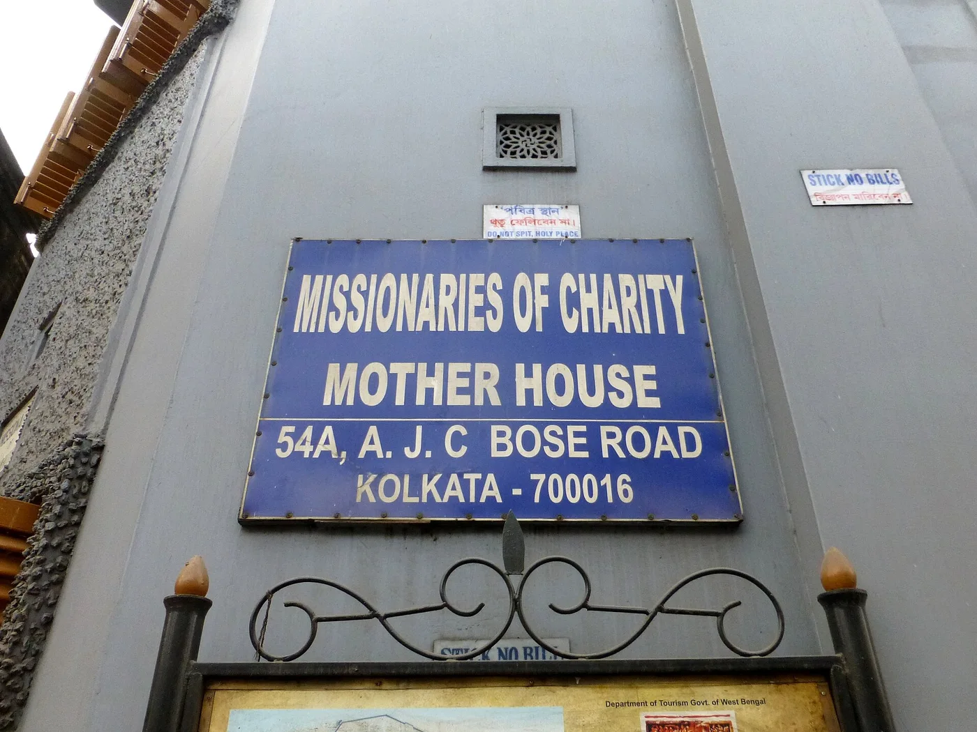 Papan nama Mother House di Kolkata. Alamat bangunan memberi konteks lokasi komunitas dan makam.